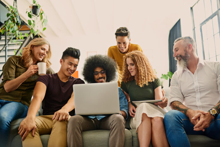 Group of adults huddled around a laptop